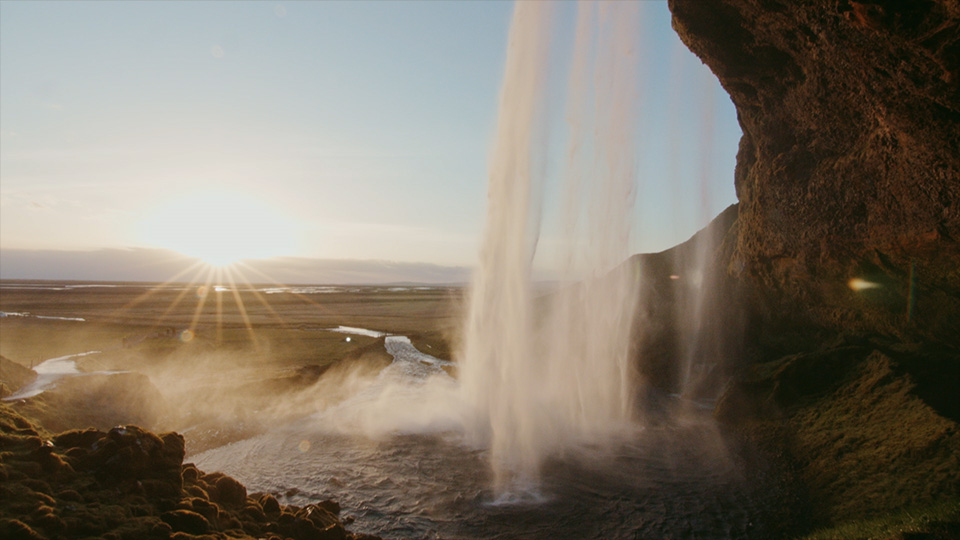 A still frame from the shot through the waterfall on sun setting in Iceland. Video promoting local business.