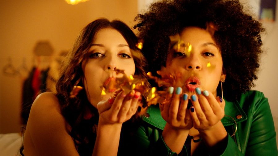 Video web series for beauty product HiHybrid: two young women blowing sequins towards the lens